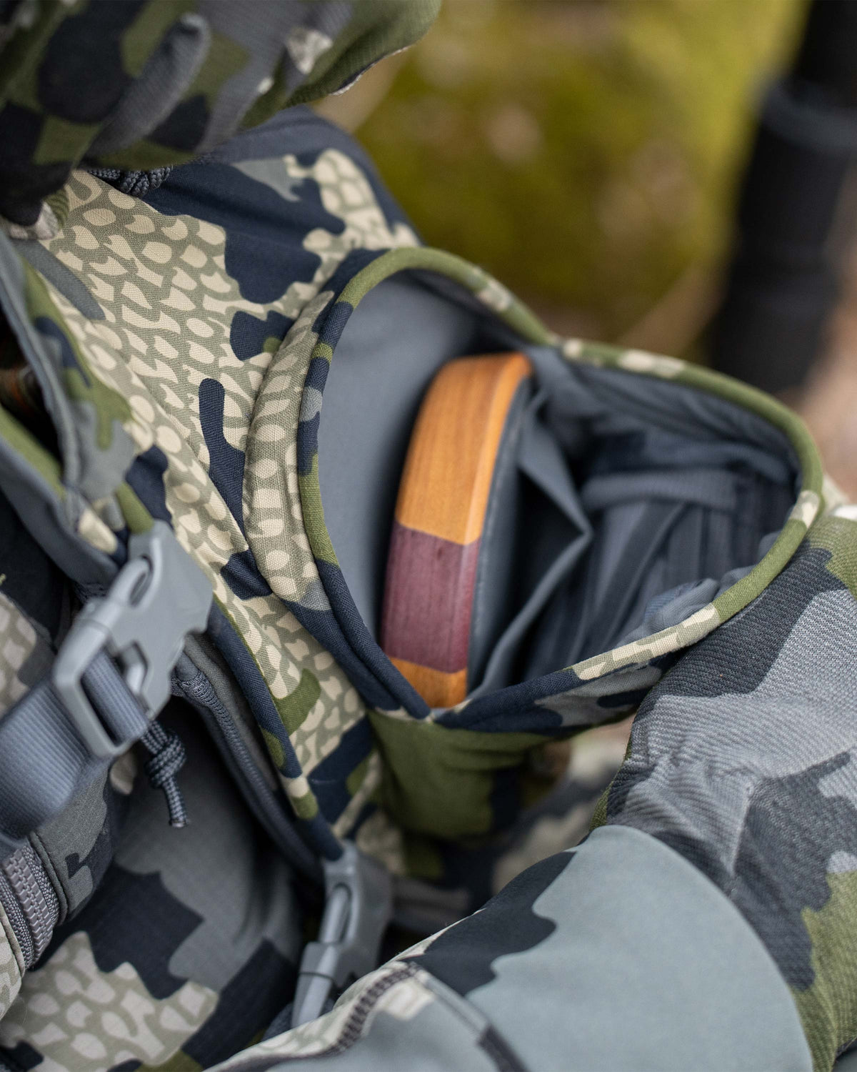 View of front internal pocket on the KUIU Rival Turkey Vest in Verde Camouflage stowed with a slate pot call