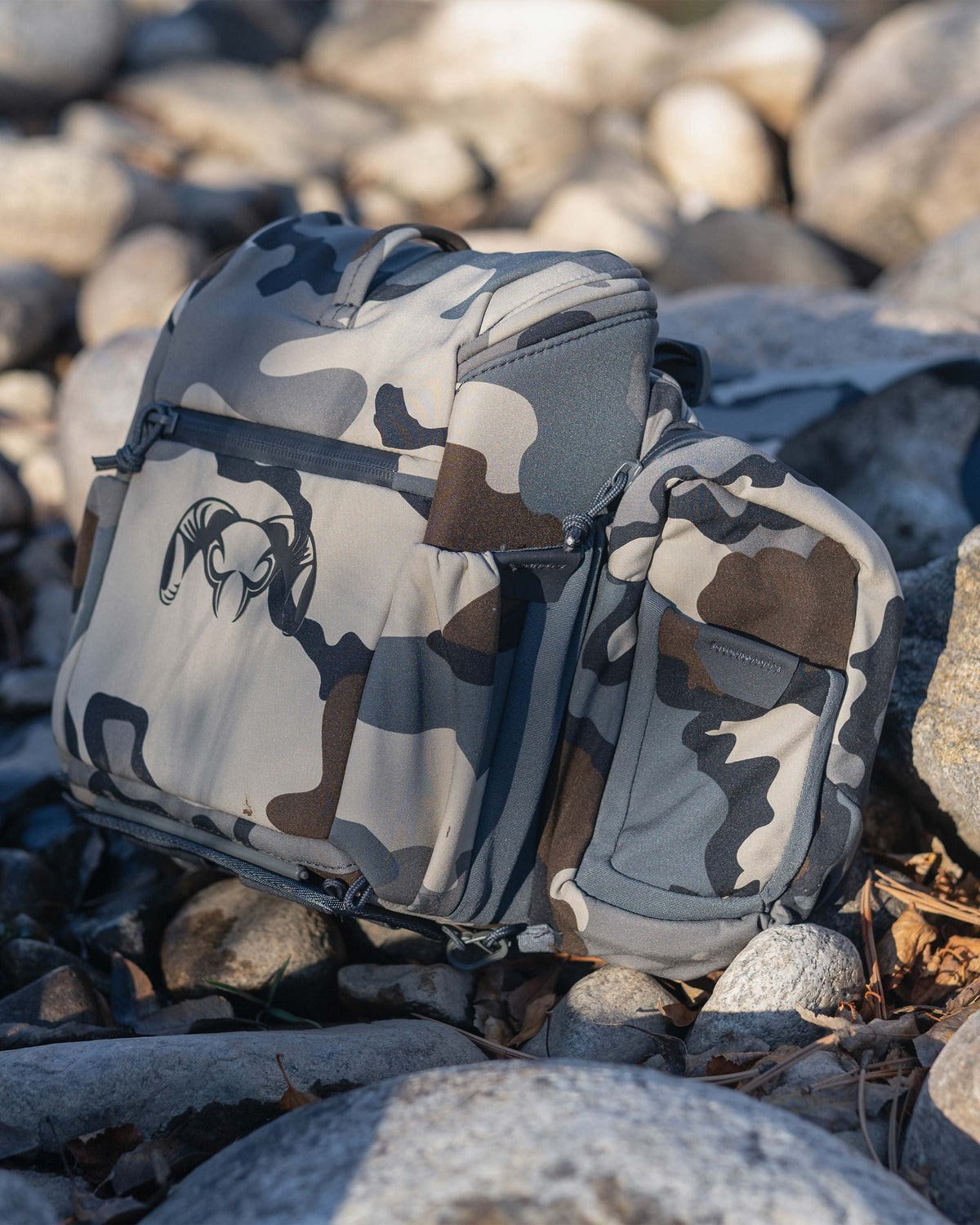 Side angle view of PRO Chest Pack in Vias Camouflage sitting on rocks