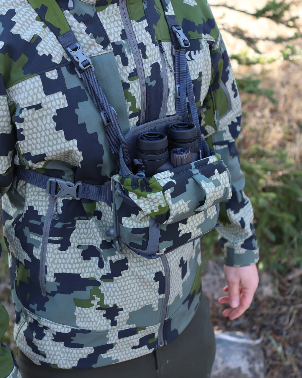 Close-up of PRO G3 Bino Harness in Verde Camouflage with binocular nestled inside the main compartment, Highlighting opened forward folding magnetic lid 