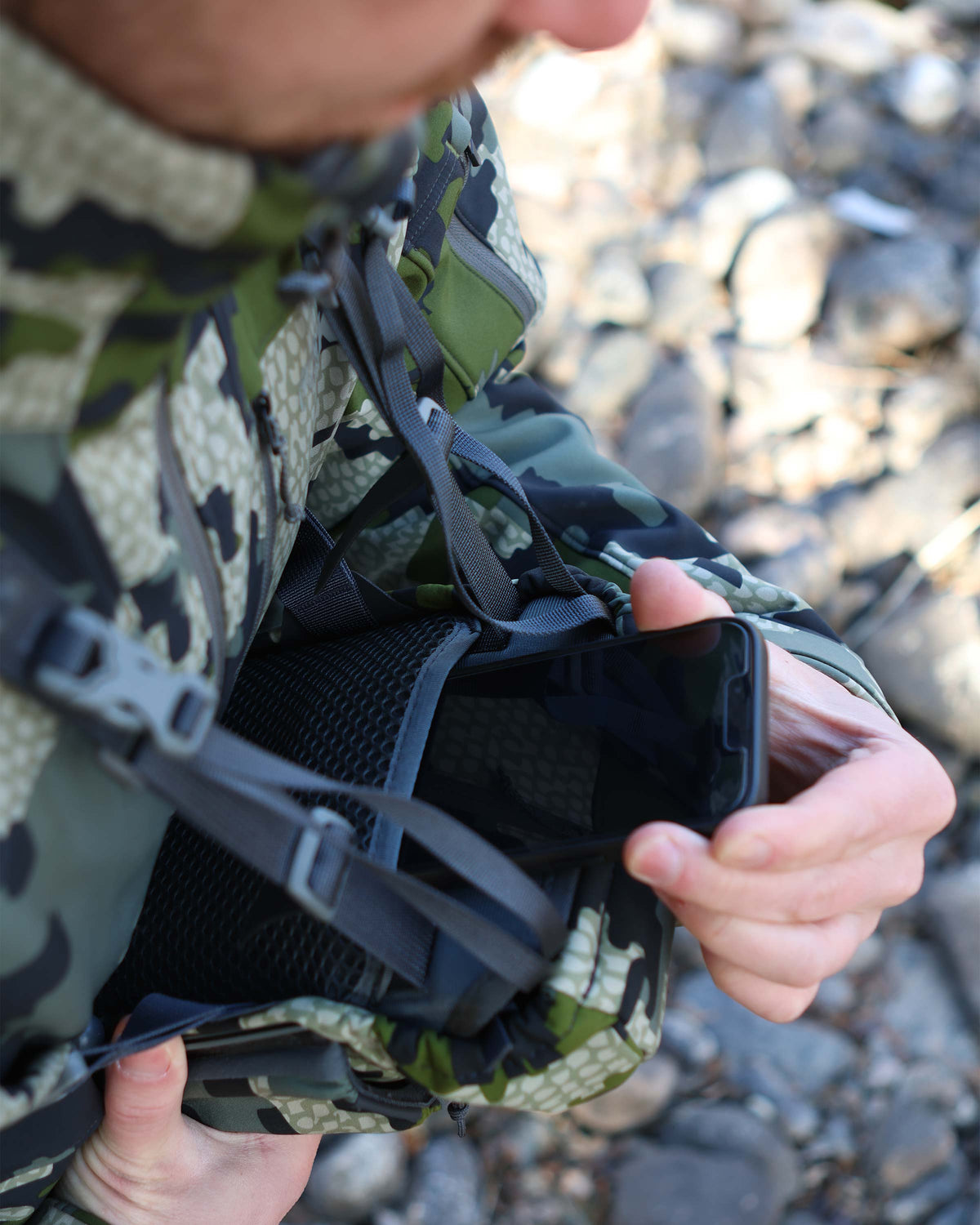 Hunter storing his cell phone inside the next-to-body drop pocket for convenient storage
