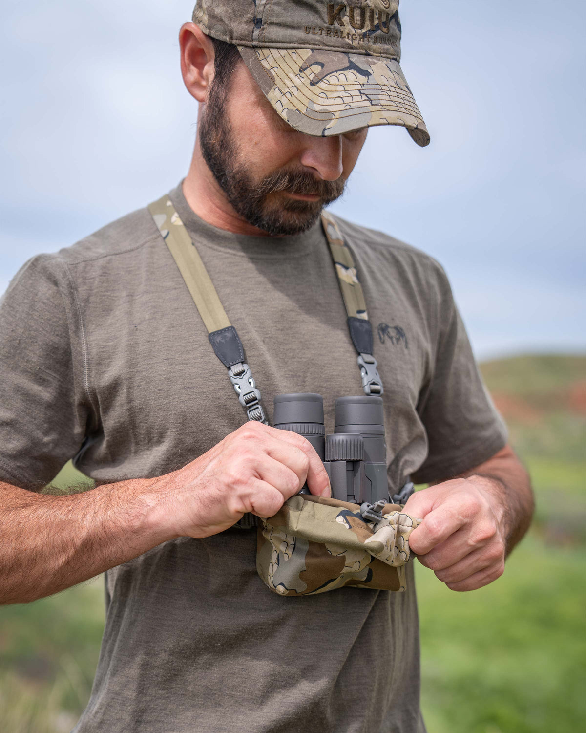 Hunter removing his binocular from front pouch of the Ultralight Bino Harness in Valo Camouflage
