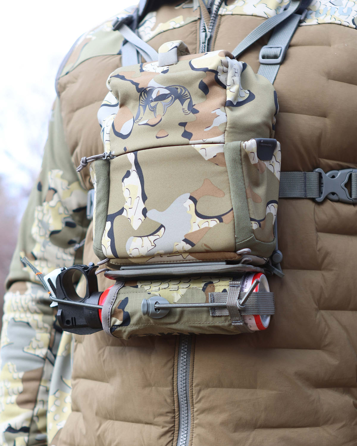 Front of Hunter wearing PRO Bino Harness with PRO G3 Bear Spray Holder in Valo Camouflage attached on the bottom of the harness utilizing rail-lock connection