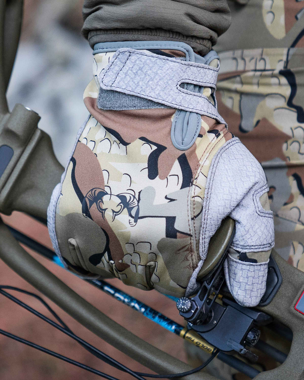 Hunter Holding Bow Wearing Guide X Gloves in Valo Camouflage