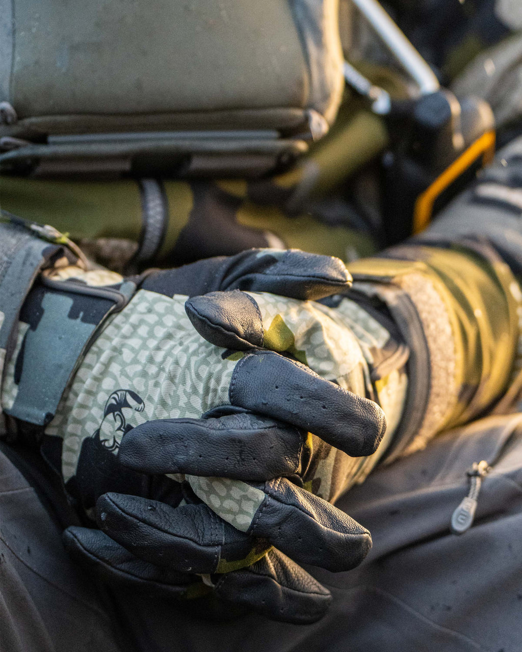 Close-up of hunter folding hands wearing Precision Glove in Verde Camouflage