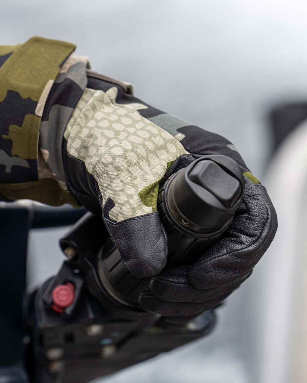 Close-up of hunter wearing Precision Glove in Verde Camouflage holding on to a motor handle