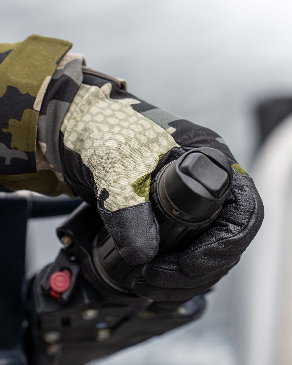 Close-up of hunter wearing Precision Glove in Verde Camouflage holding on to a motor handle