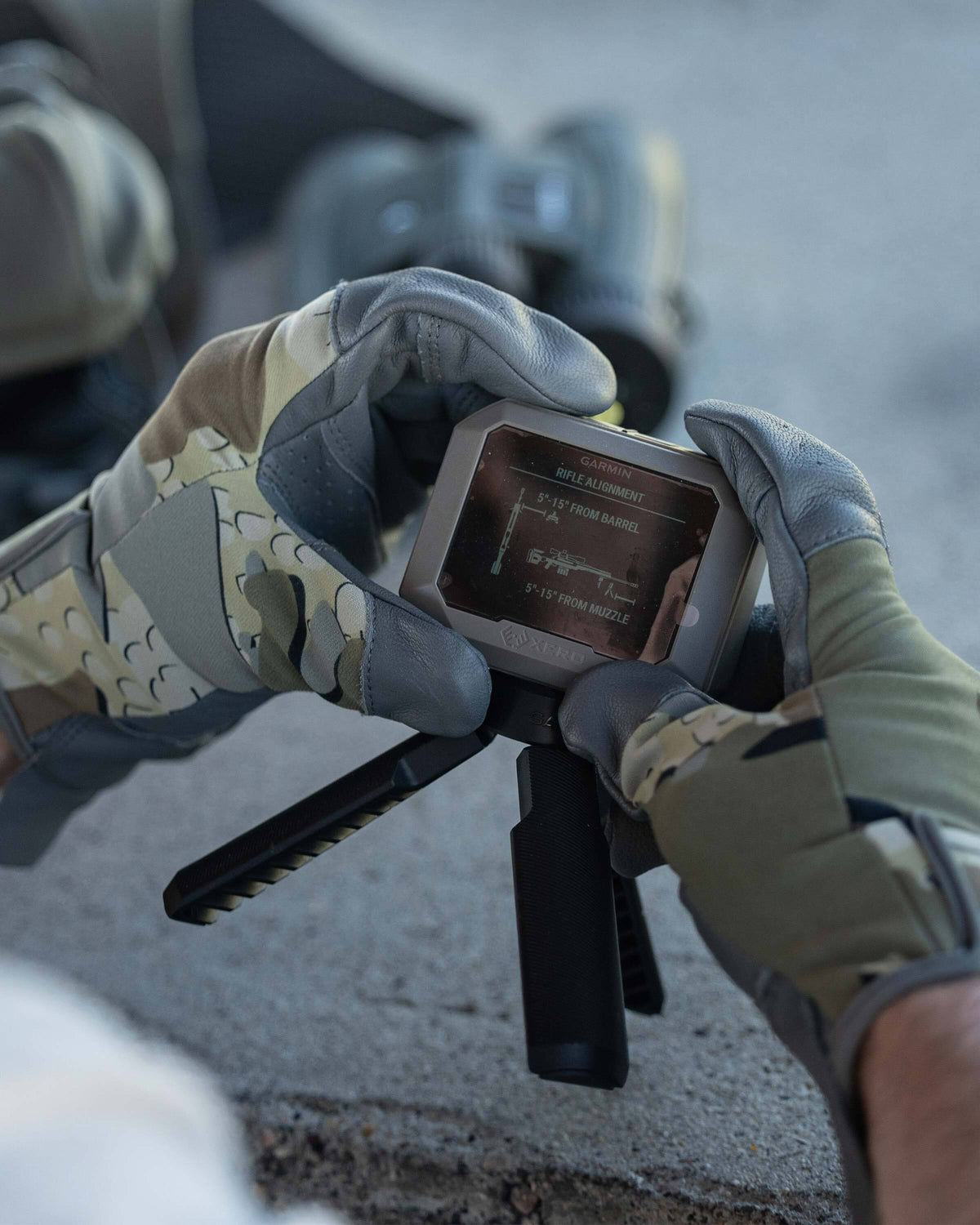 Hunter wearing Precision Glove in Valo Camouflage holding a Garmin Xero Chronograph