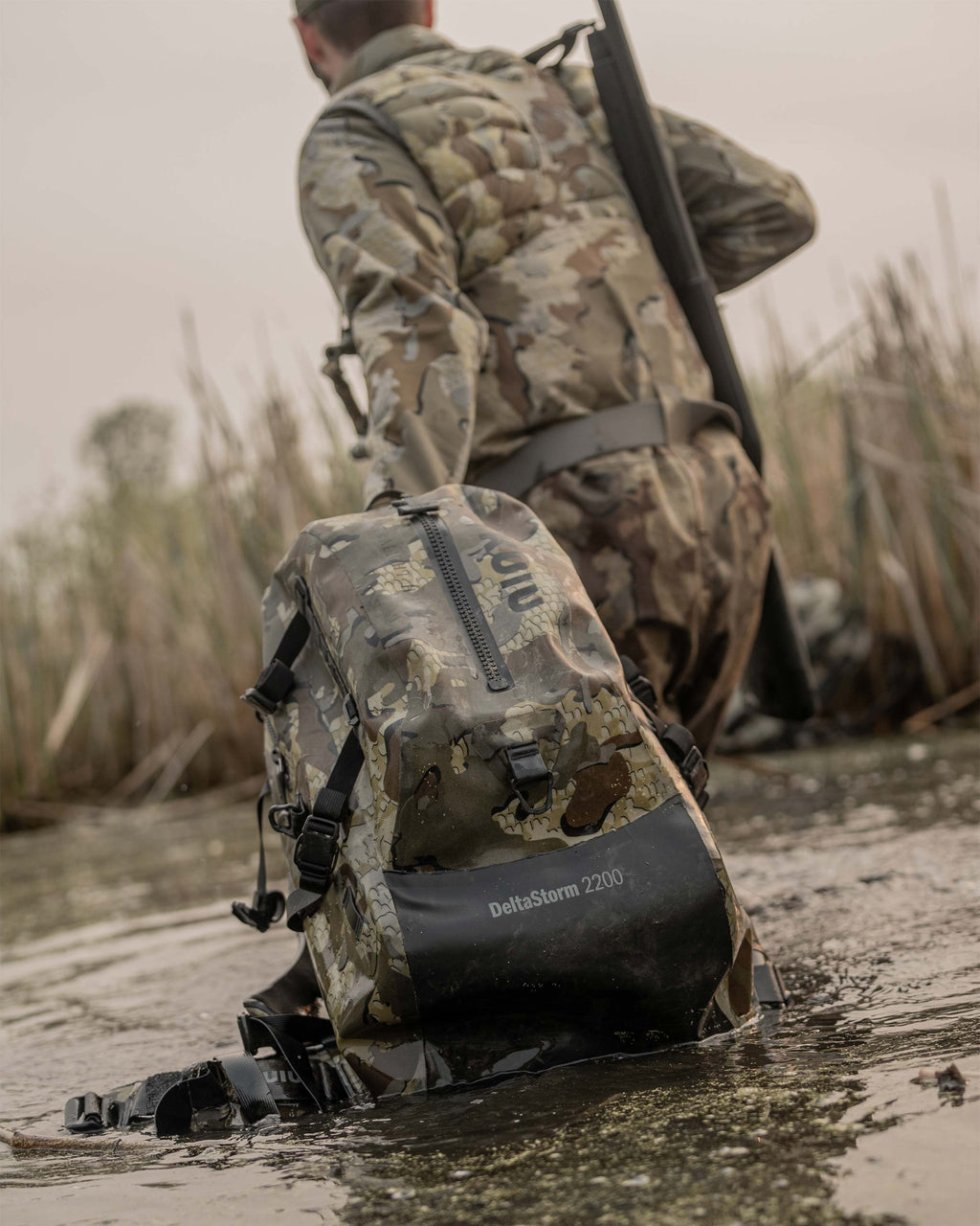 Delta Storm 2200 Submersible Backpack Being dragged through the water by Man in Valo Camouflage