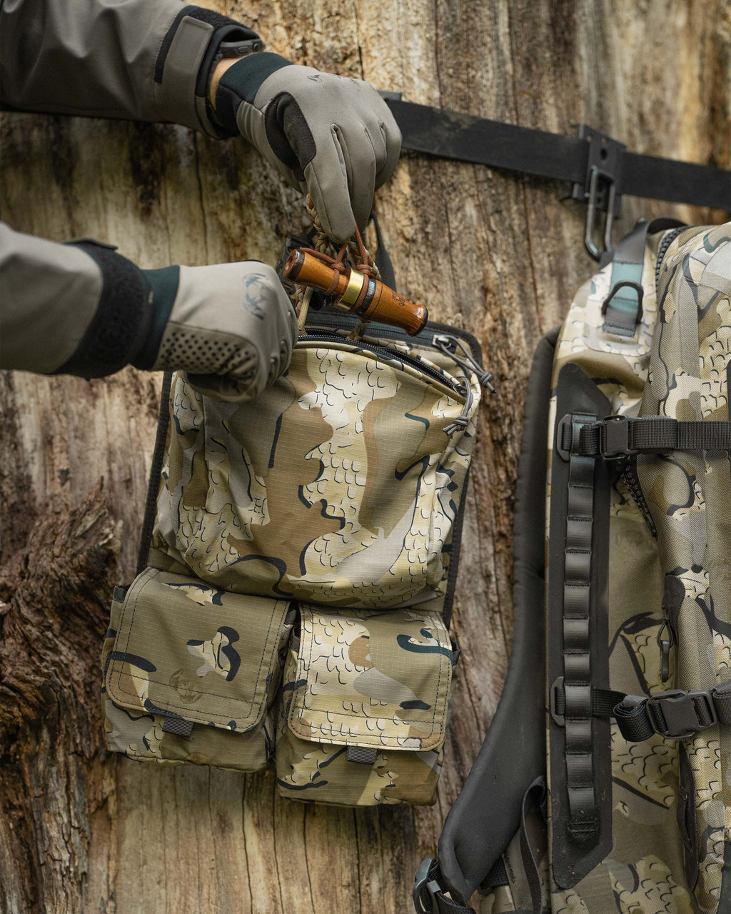 Delta Storm 2200 Submersible Backpack internal accessory pocket shown hanging on a tree next to the bag itself in Valo Camouflage