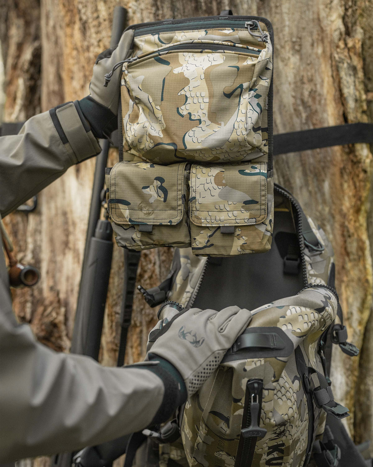 Delta Storm 2200 Submersible Backpack internal accessory pocket shown Being held by a Man near a tree in Valo Camouflage