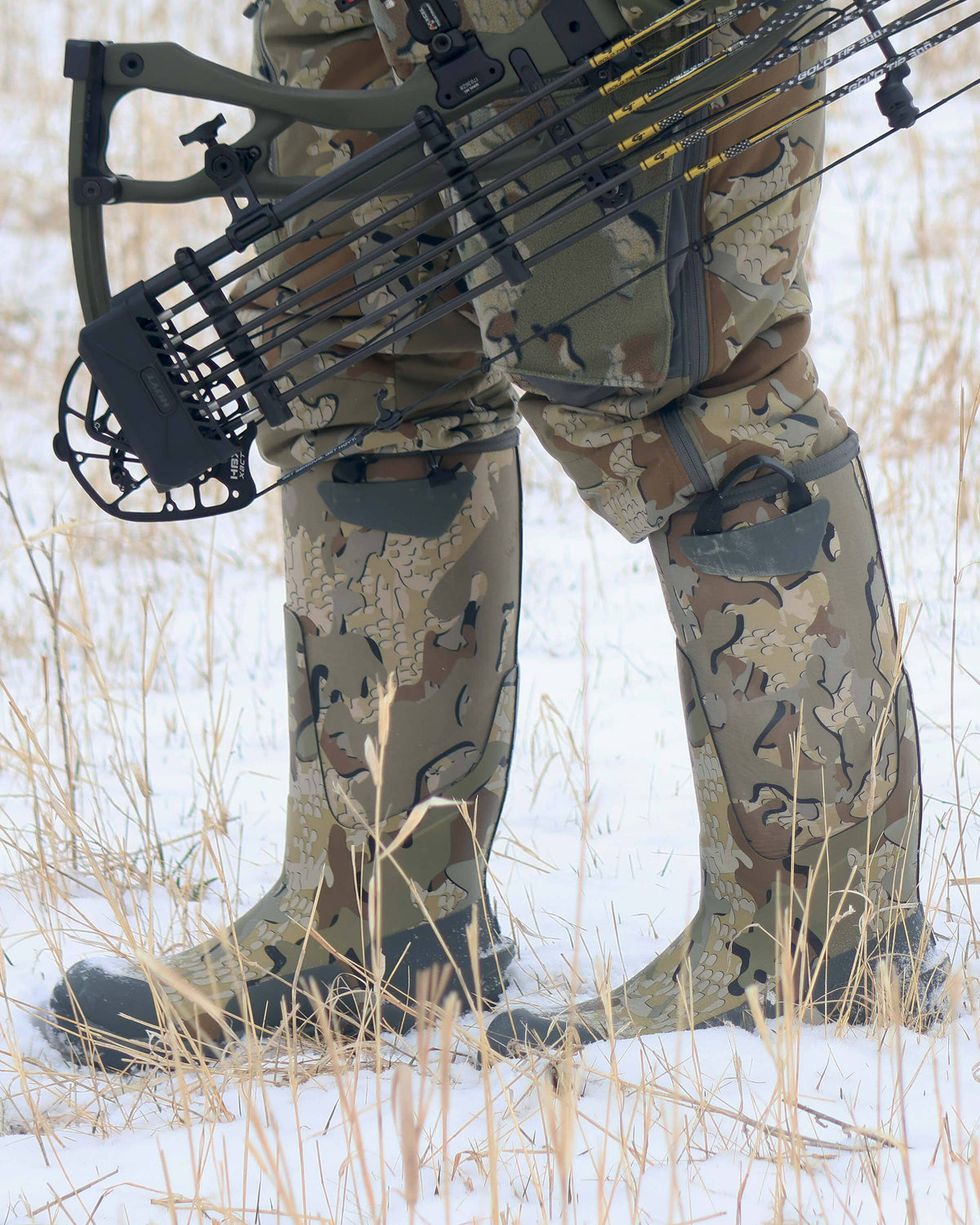 Close-up side view of hunter walking in the snow in KUIU Mud Boot Valo Camouflage