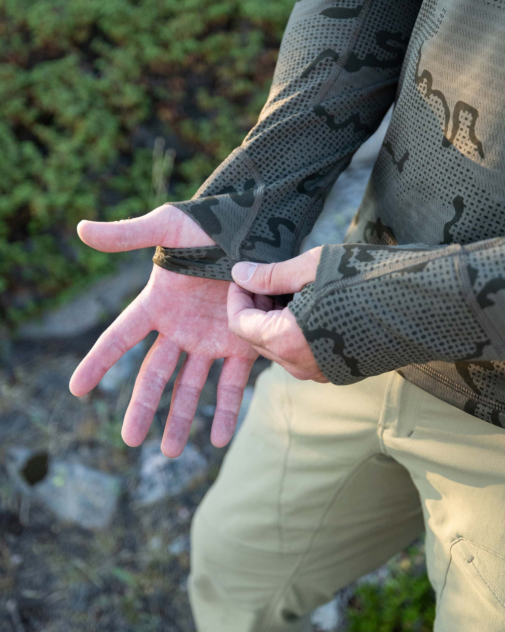 Close-up view of Hunter showing layered thumbhole on his Ridgepoint Fleece Henley in Olive Green Tonal Pattern