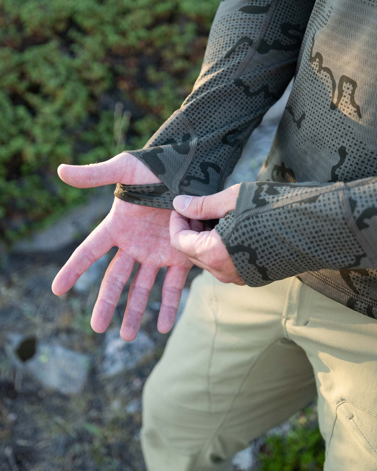 Close-up view of Hunter showing layered thumbhole on his Ridgepoint Fleece Henley in Olive Green Tonal Pattern