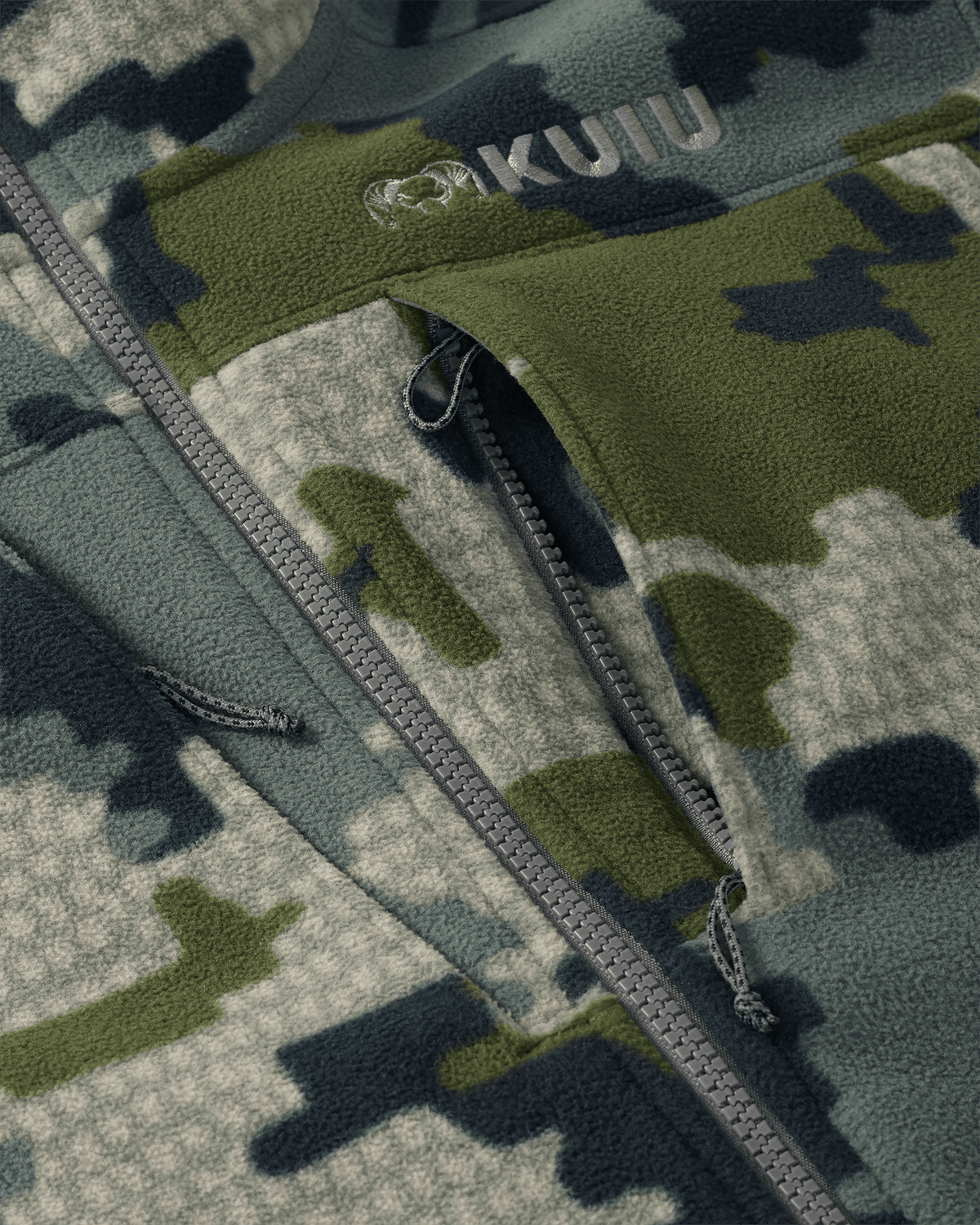 Close-up of front unzipped chest pocket and embroidered KUIU logo on Proximity LT Hooded Jacket in Verde Camouflage