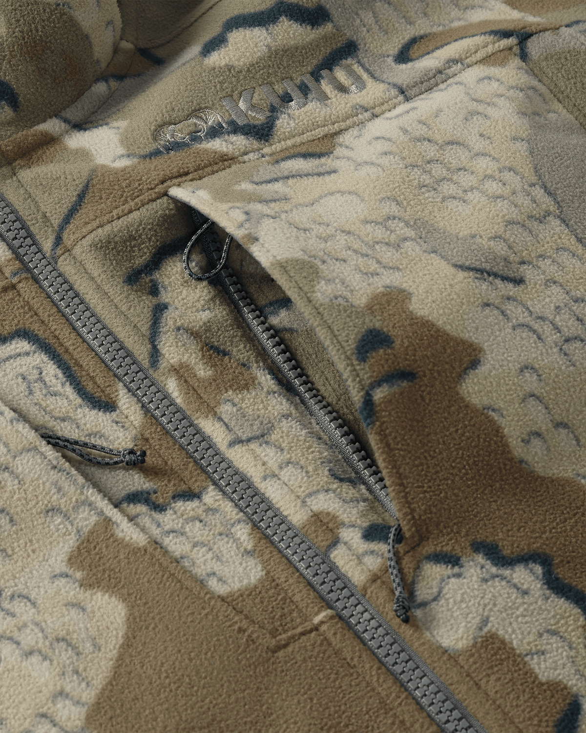 Close-up of front unzipped chest pocket and embroidered KUIU logo on Proximity LT Hooded Jacket in Valo Camouflage