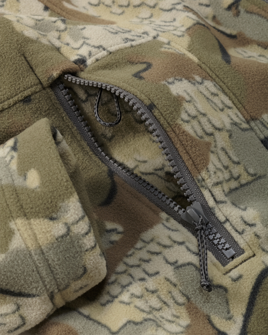 Zippered hand pocket with accessory connection lanyard on the KUIU Women's Border Fleece Jacket in Valo Camouflage.