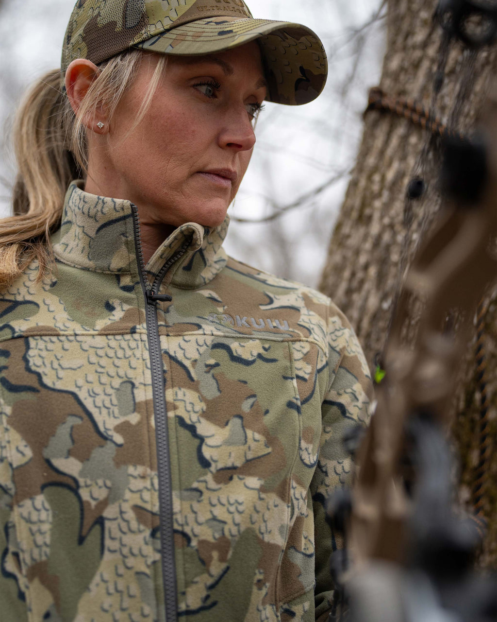 Close-up view of woman hunter, Highlighting front of the Women's Border Fleece Full Zip Jacket in Valo Camouflage  