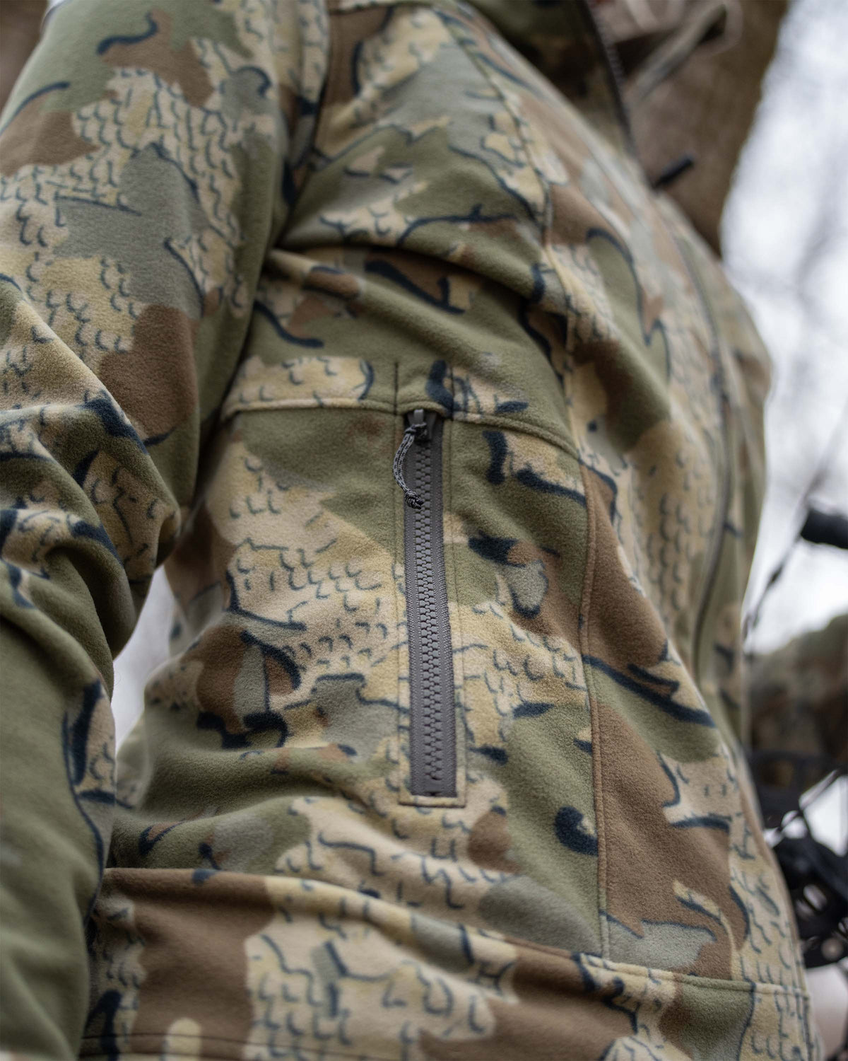 Close-up of side zippered pocket on the Women's Border Fleece Full Zip Jacket in Valo Camouflage