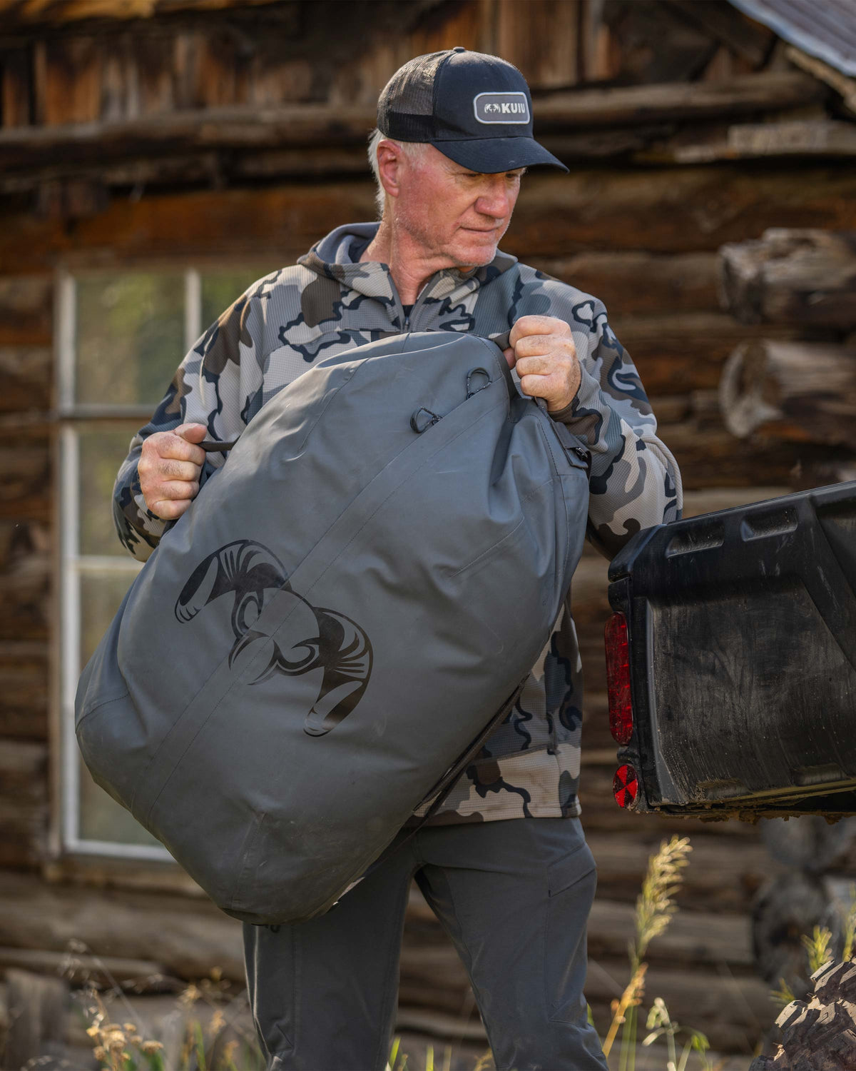 Hunter loading BLSTX 4200 Duffel in Gunmetal Grey to the rear of a UTV