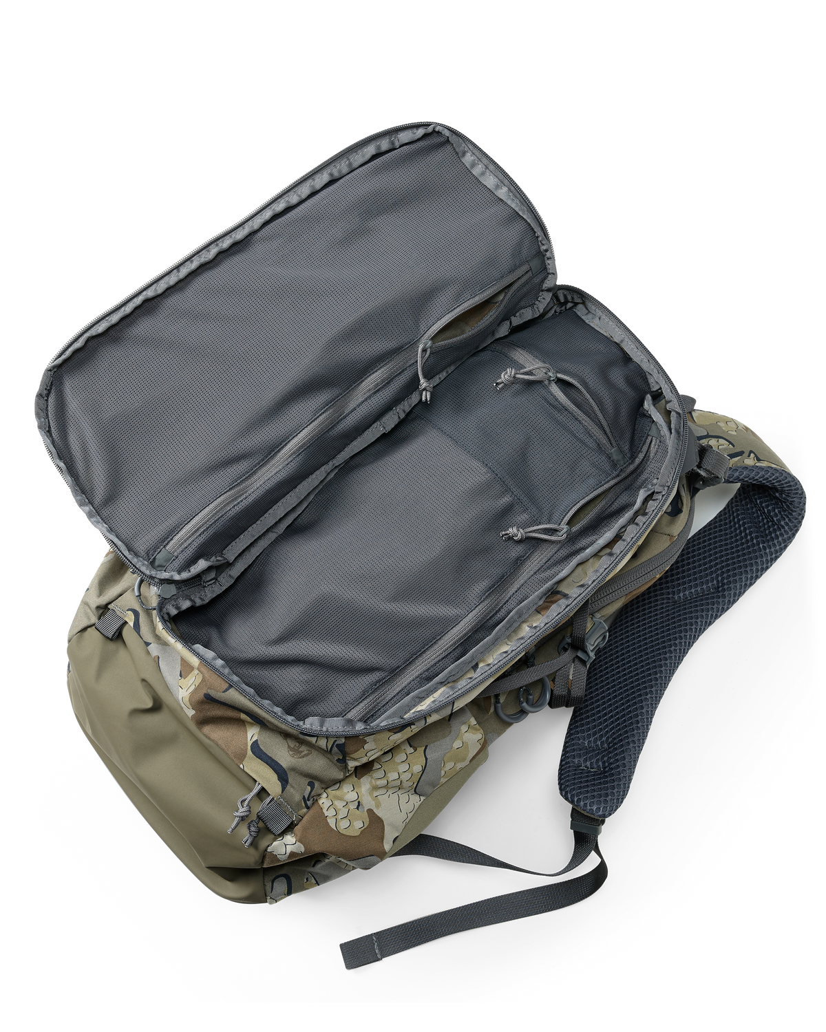 Divide 1500 in Valo Camouflage laid on studio flow with front pocket unzipped to show storage