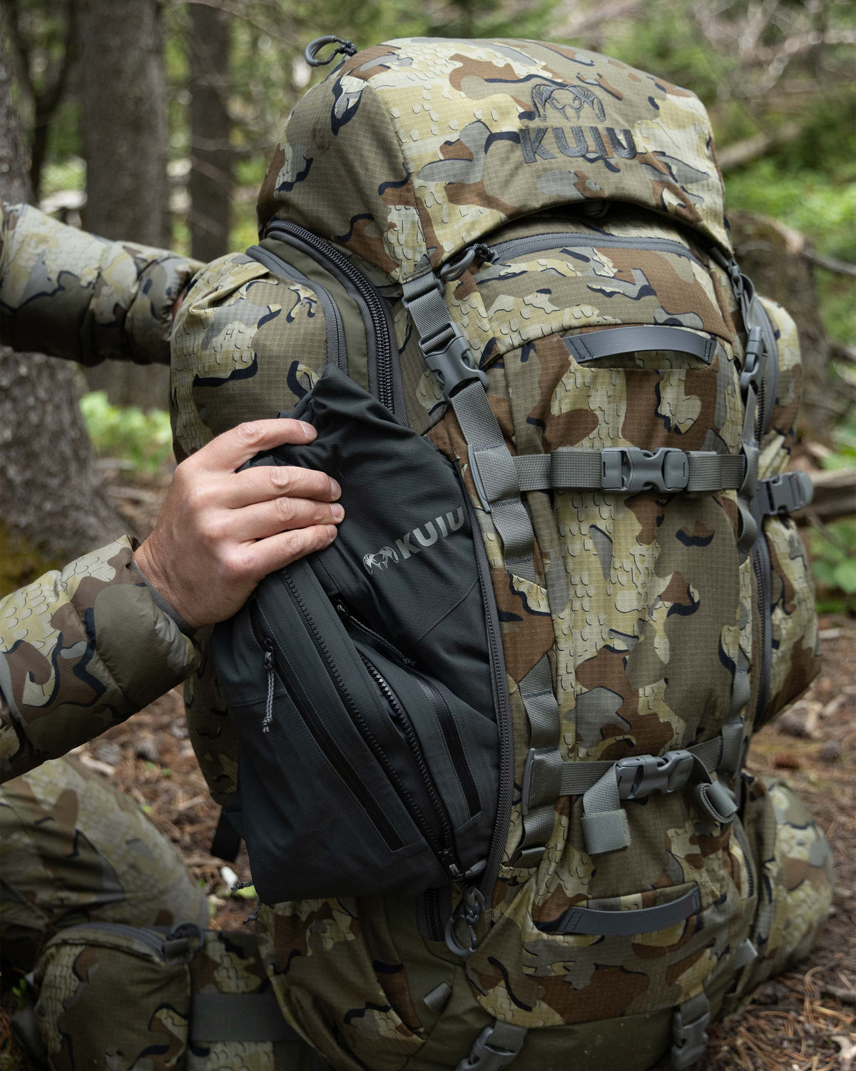 Hunter showing side-access exterior pocket for rain gear clothing items on an ICON 8200 Pack in Valo Camouflage.