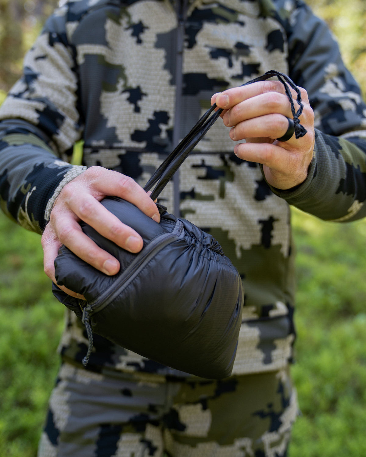 Hunter Utilizing Self Stow Option on Super Down LT Vest in Verde Camouflage