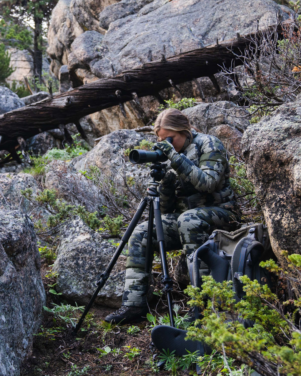 Hunter Watching Game Through Spotting Scope Wearing Women's Super Down LT Jacket and Pants in Verde Camouflage