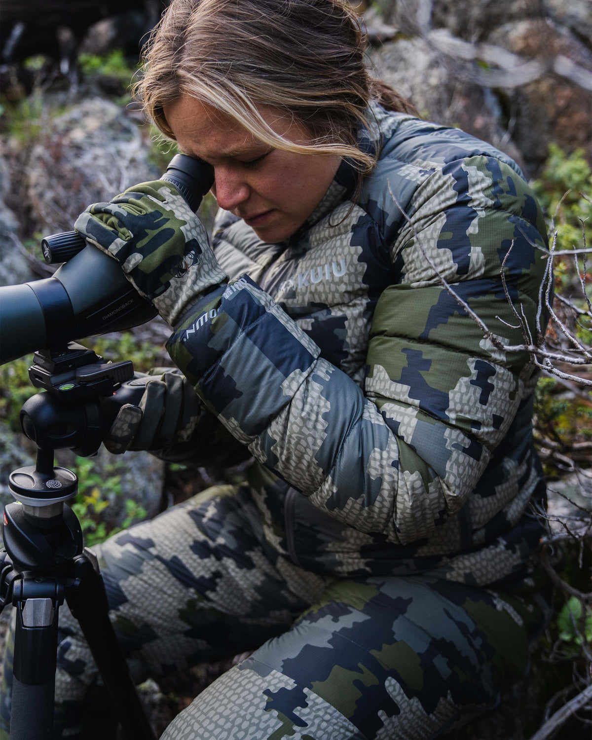 Hunter Watching Game Through Spotting Scope Wearing Women's Super Down LT Jacket and Pants in Verde Camouflage