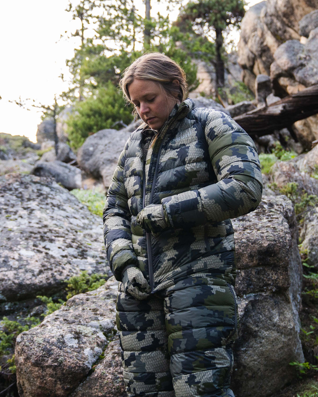 Hunter Zipping Up Women's Super Down LT Jacket in Verde Camouflage in Rocky Terrain