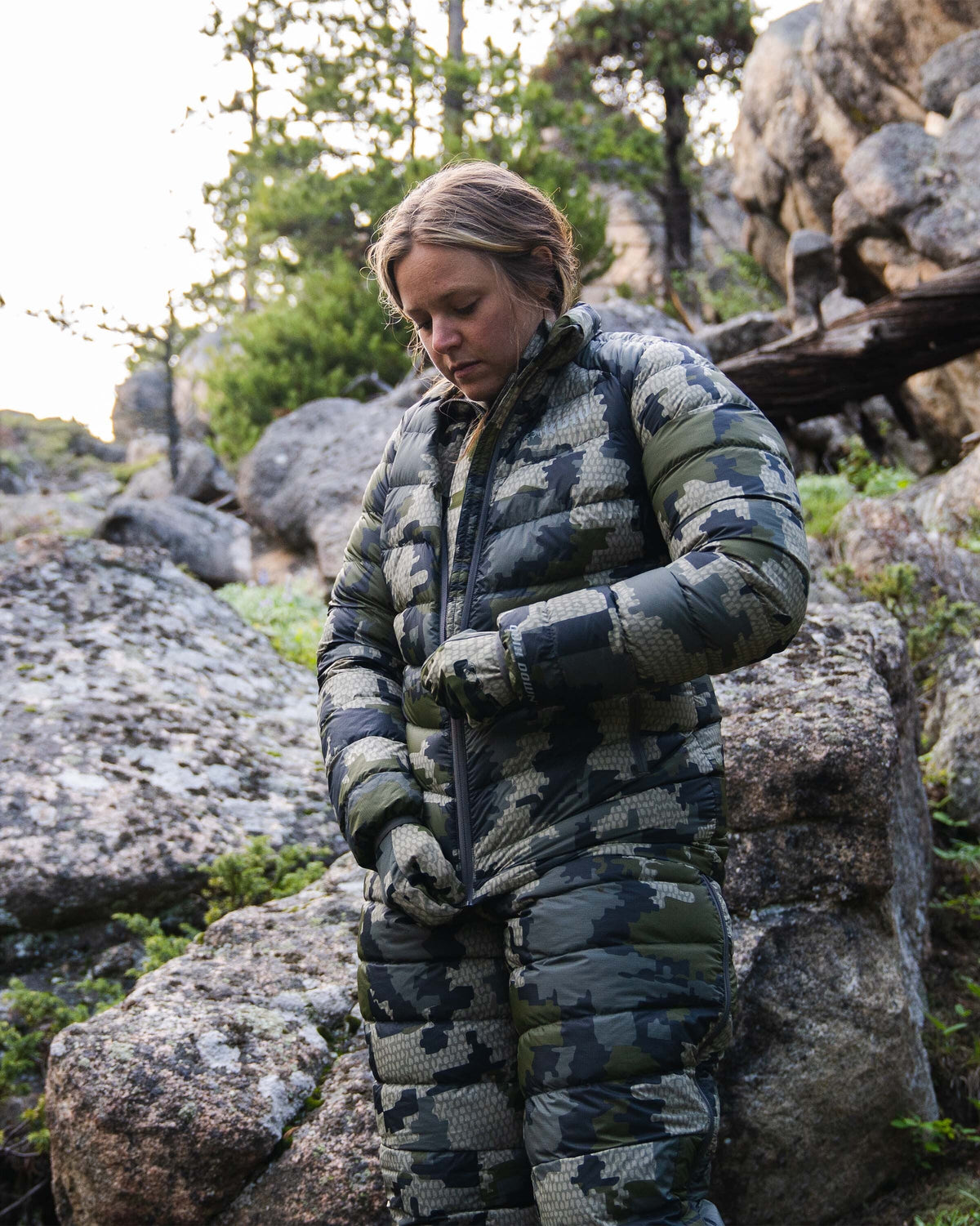 Hunter Zipping Up Women's Super Down LT Jacket in Verde Camouflage in Rocky Terrain