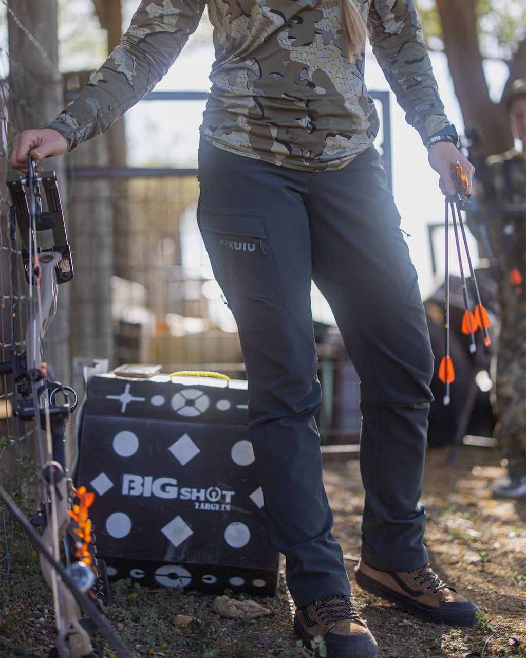 Front of Hunter Holding Bow and Arrows Wearing Women's Attack Pant in Gunmetal Grey Color