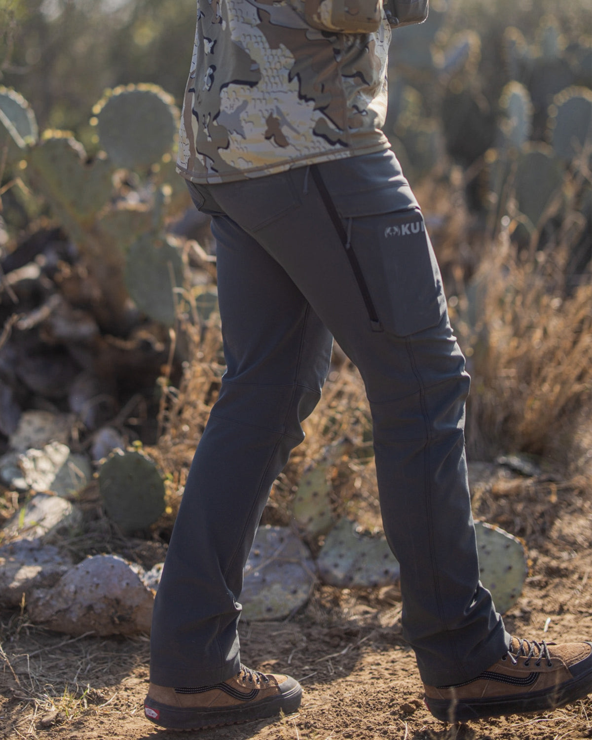 Hunter Walking in Front of Prickly Pear Cactus Wearing Women's Attack Pants in Gunmetal Grey Color