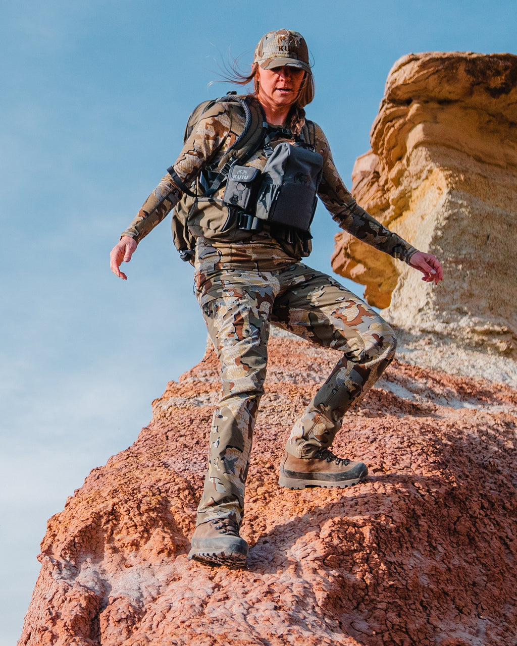 Female hunter side stepping down rock wearing Women's Attack Pant in Valo Camouflage