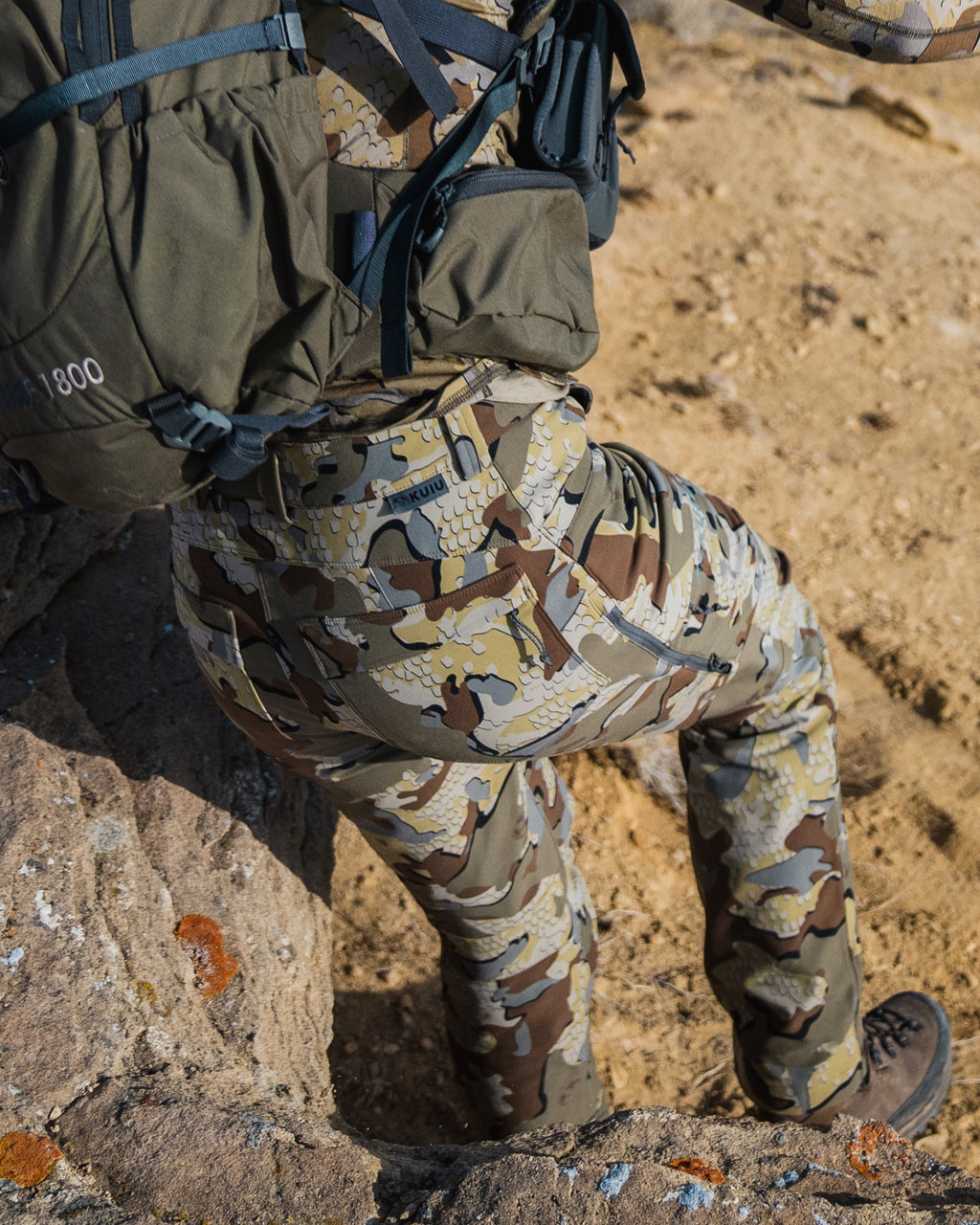 Detail of female hunter going down steep rock wearing Women's Attack Pant in Valo Camouflage