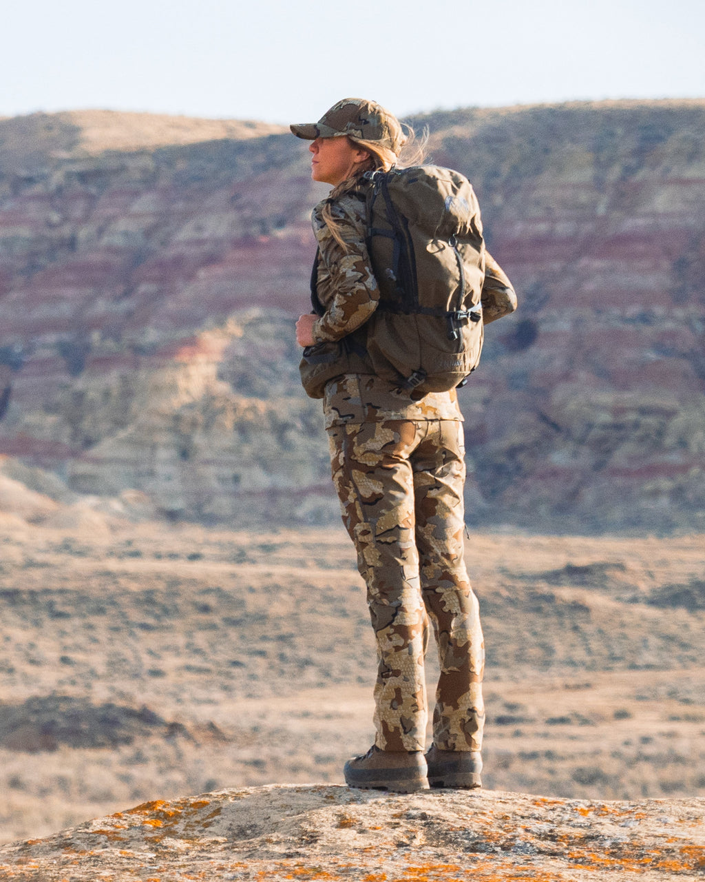 Female hunter standing at edge of bluff wearing Women's Attack Pant in Valo Camouflage