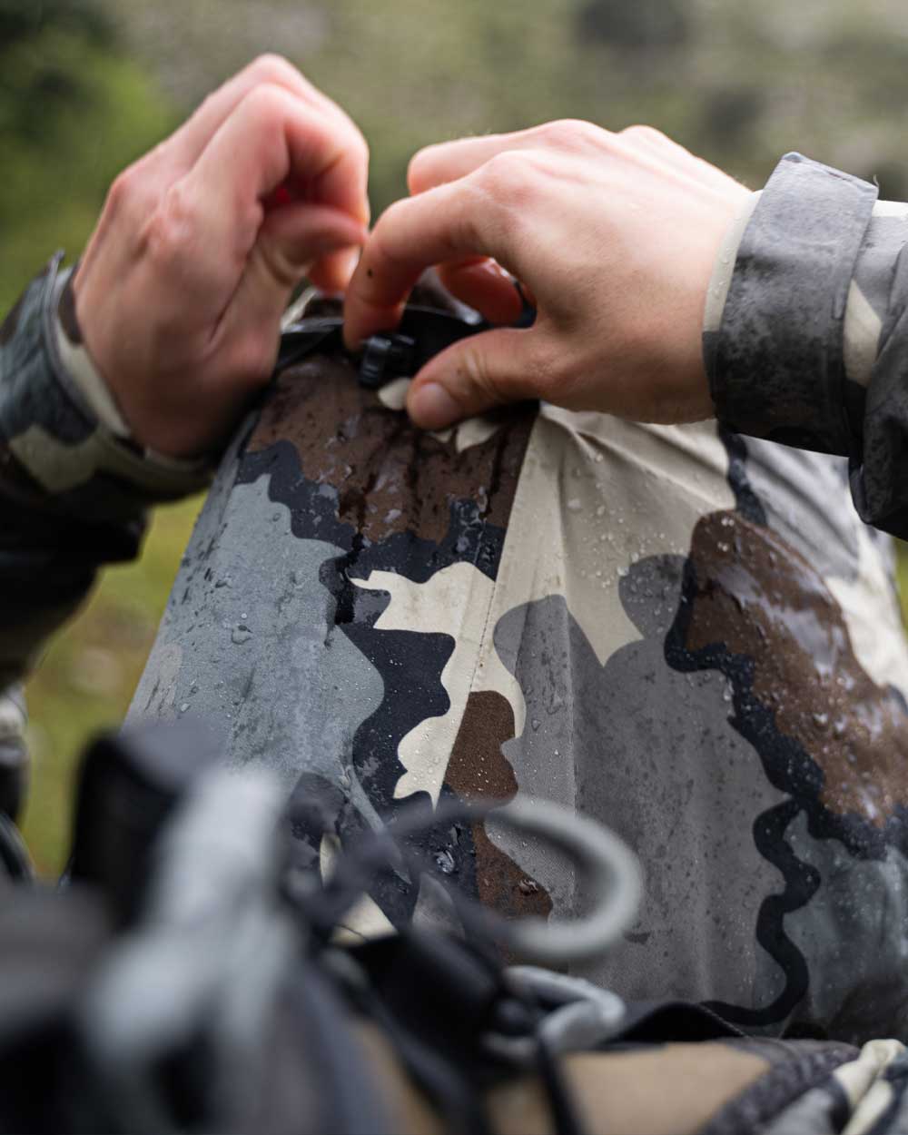 Back of Hunter Wearing Women's Chugach TR Rain Jacket in Vias Camouflage Highlighting Adjustable Hood