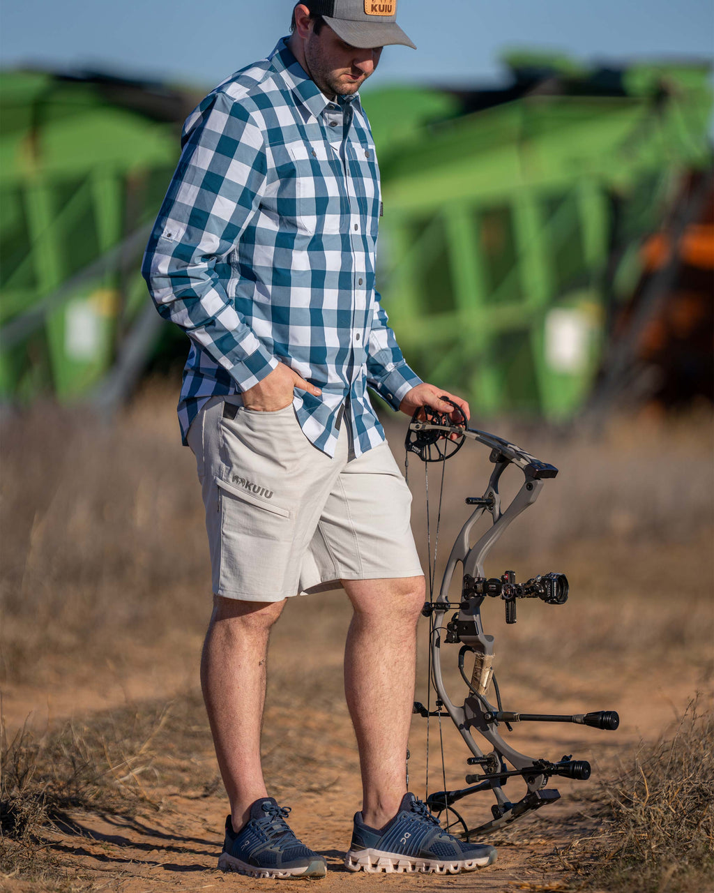 Hunter wearing Switchback Short in Lunar Grey, standing with left hand on his bow and right hand in this pocket