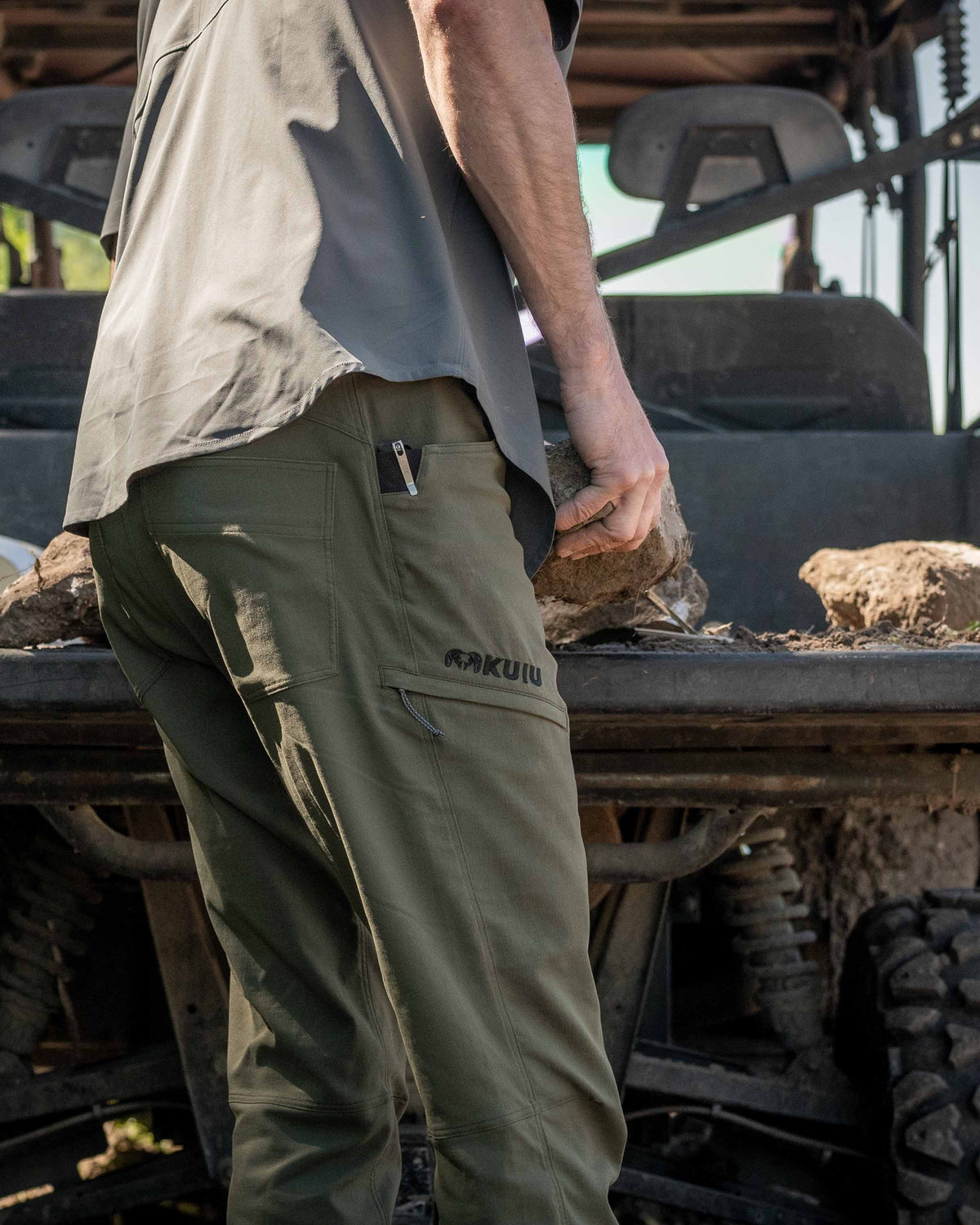 Side of Hunter Wearing Switchback Pants in Olive Green Color Highlighting Reinforced Right Hand Knife Feature