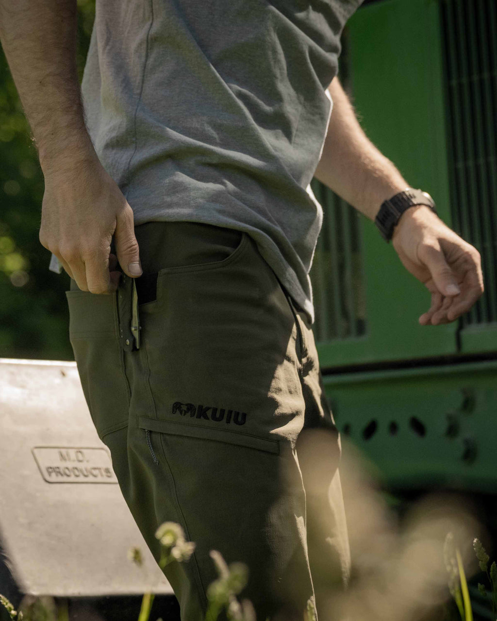 Side of Hunter Wearing Switchback Pants in Olive Green Color Highlighting Reinforced Right Hand Knife Feature