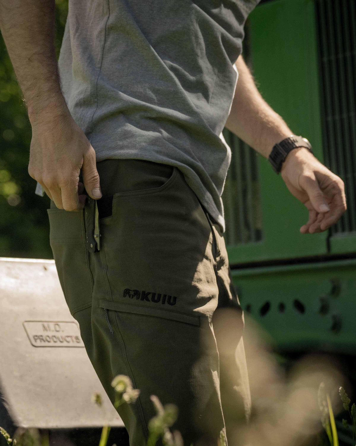 Side of Hunter Wearing Switchback Pants in Olive Green Color Highlighting Reinforced Right Hand Knife Feature