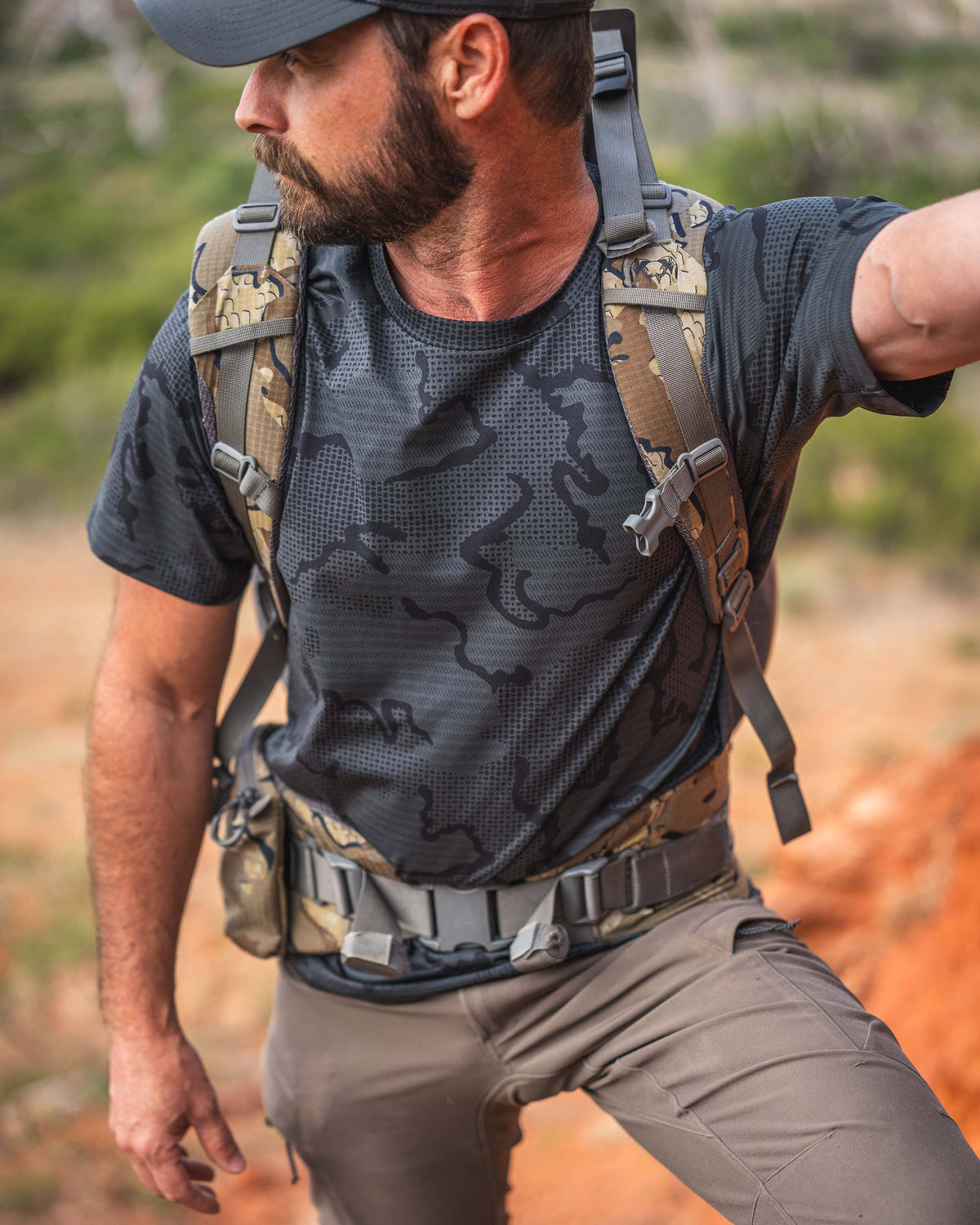 Close-up of a man wearing TrailTrainer Short Sleeve in Dark Iron Tonal looking out from a scenic vantage point.