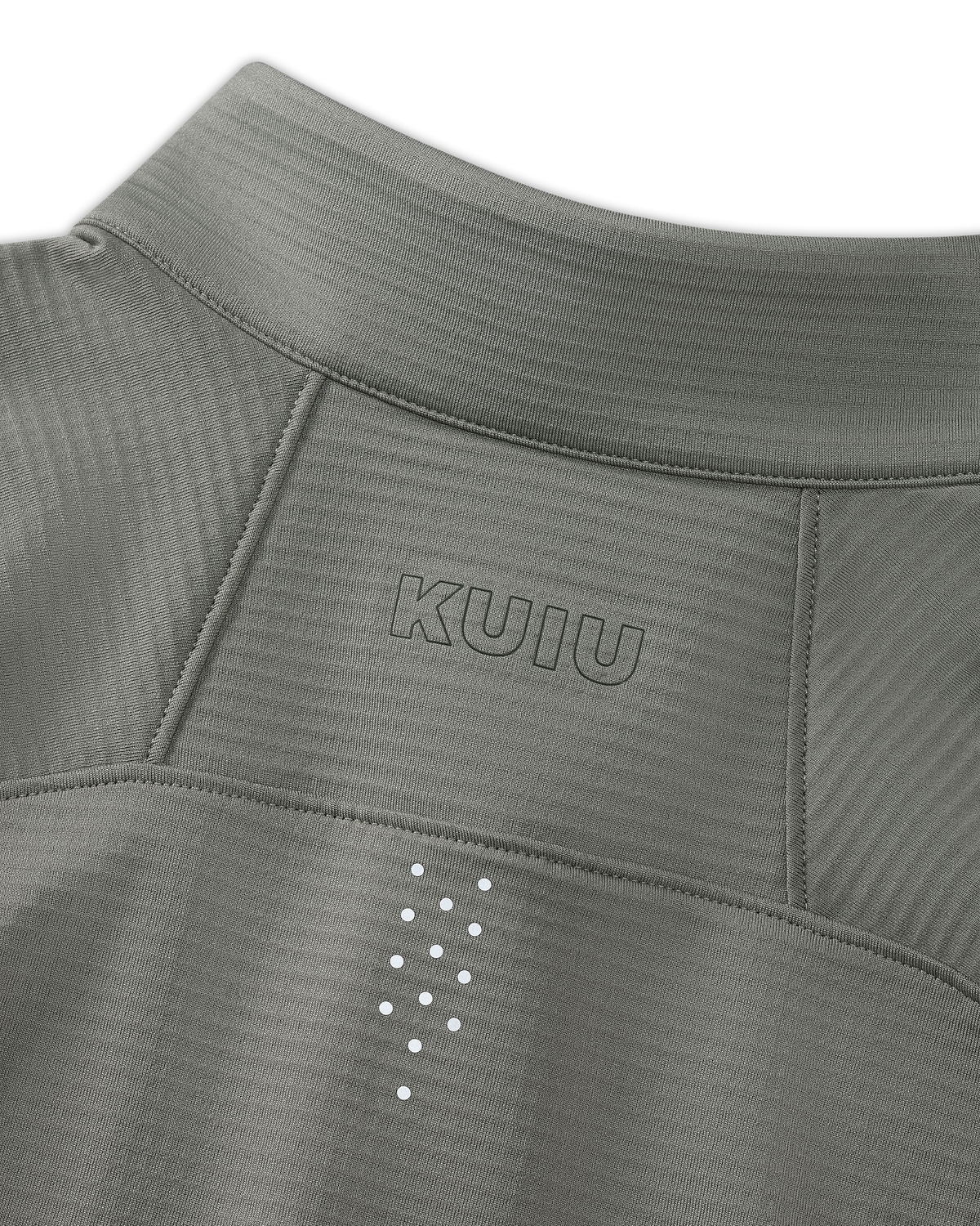 Close-up of upper back KUIU Euduro Trainer Zip-T in Shadow Grey, showing fabric subtle horizontal texture, KUIU logo printed above small reflective dots arranged vertically between the shoulder blades