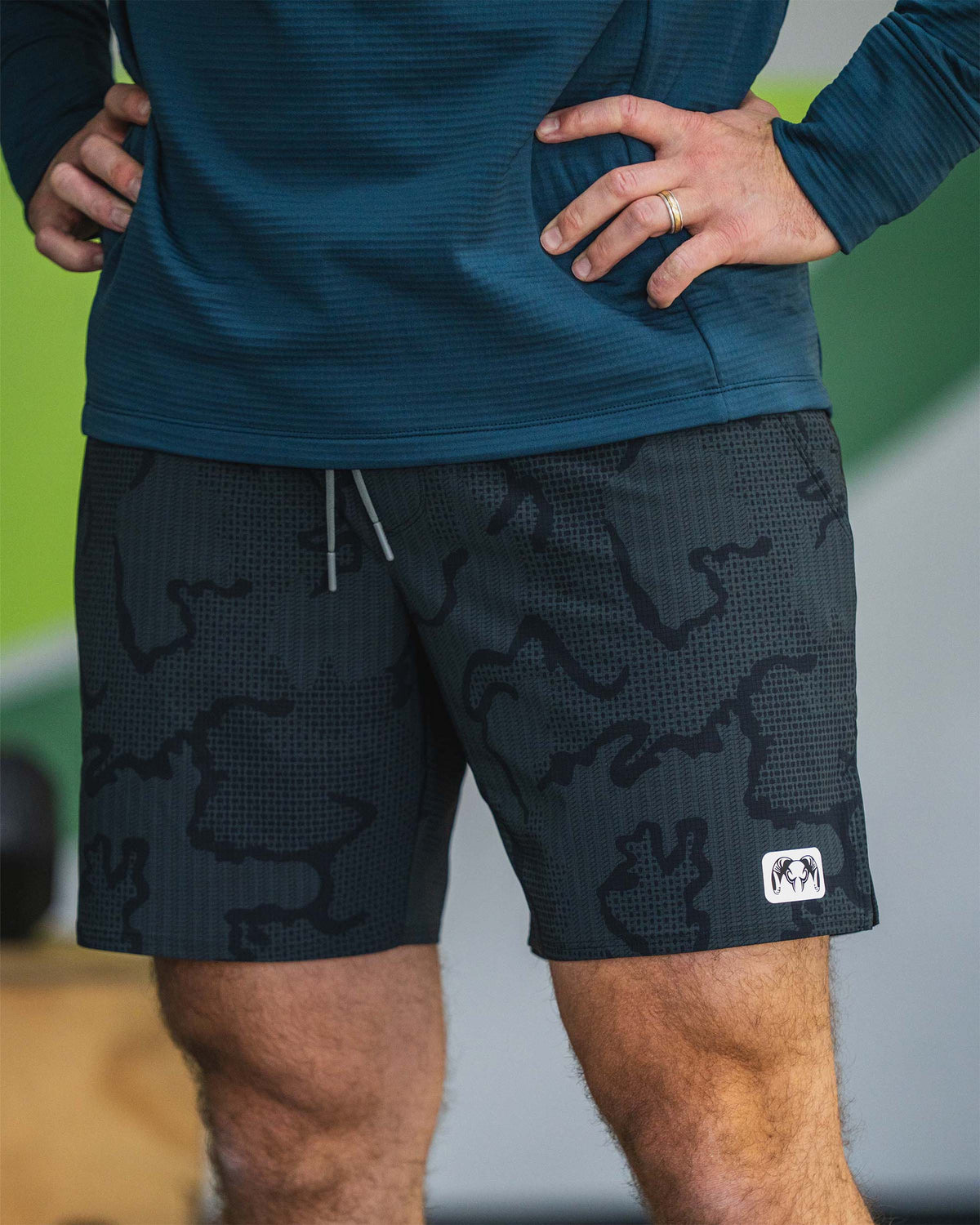 Close of man resting hands on his hips wearing KUIU Enduro Trainer 7" Short in Dark Iron Tonal 