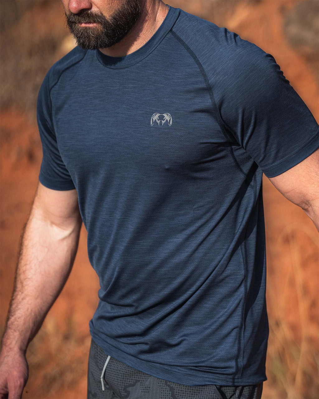 Man in an outdoor setting wearing a EnduroMesh Short Sleeve Crew in Midnight Blue Heather