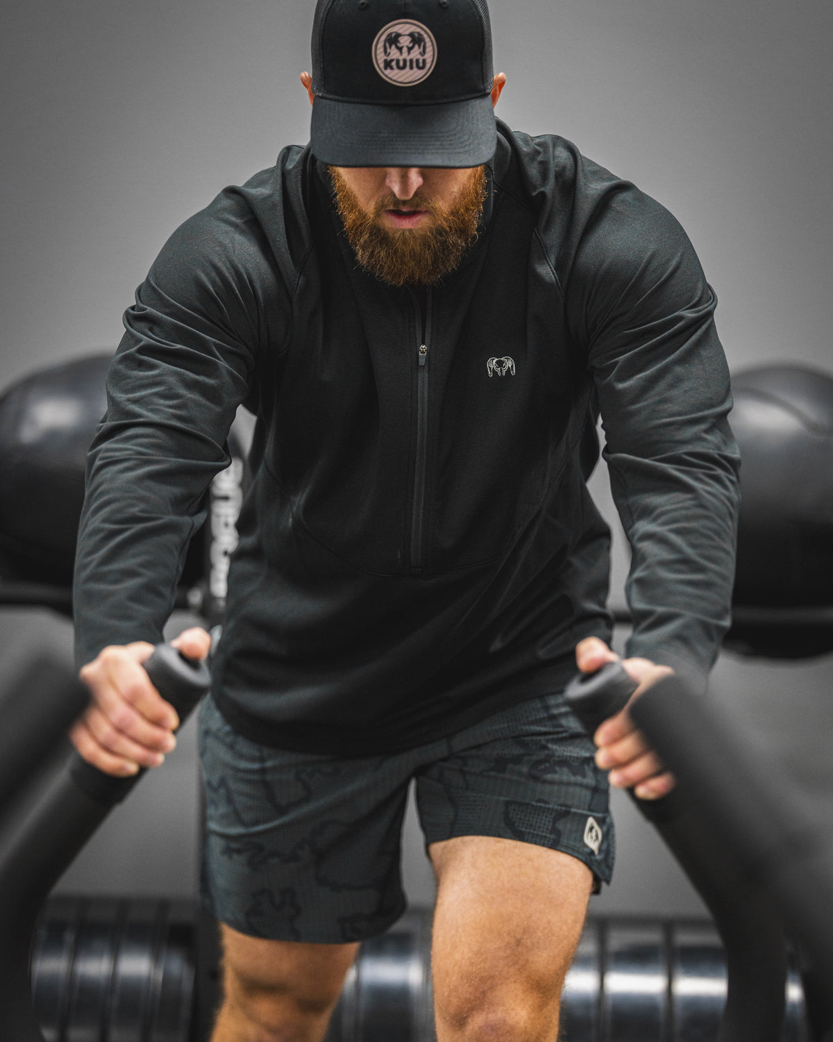 Man training with weight equipment wearing a TrailTrainer Fleece Zip-T in Black