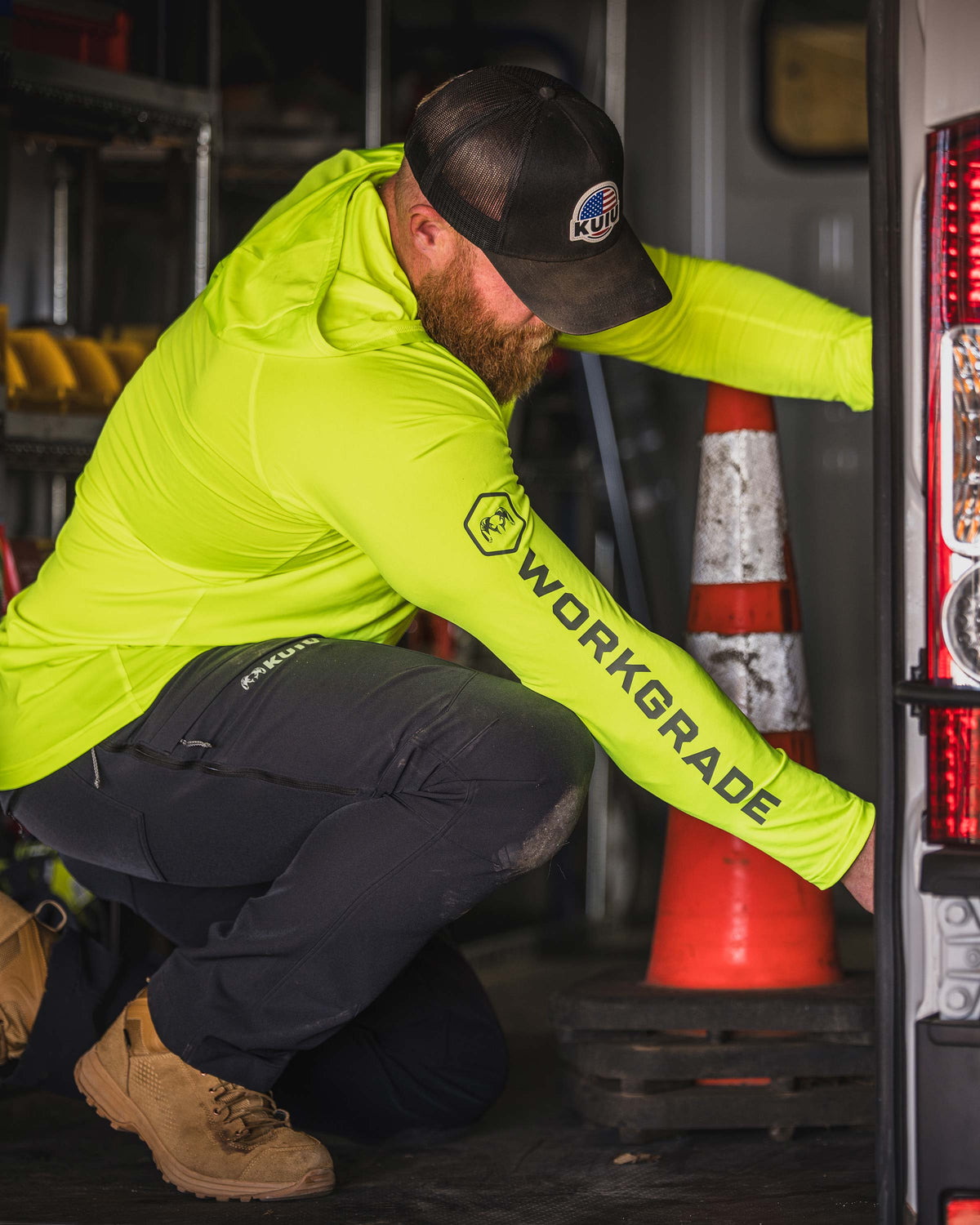 Man kneeling in an indoor utility room, appear to be reaching for something, wearing Workgrade Long Sleeve Sun Hoodie in neon yellow‑green Highlight color