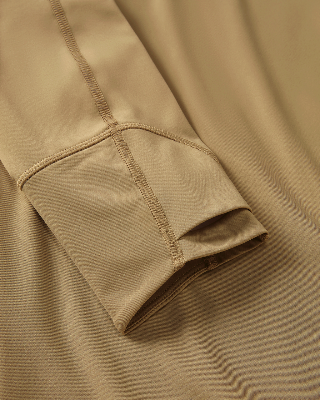 Close-up detail of layered thumbhole on Gila LS Hoodie in Dune Khaki