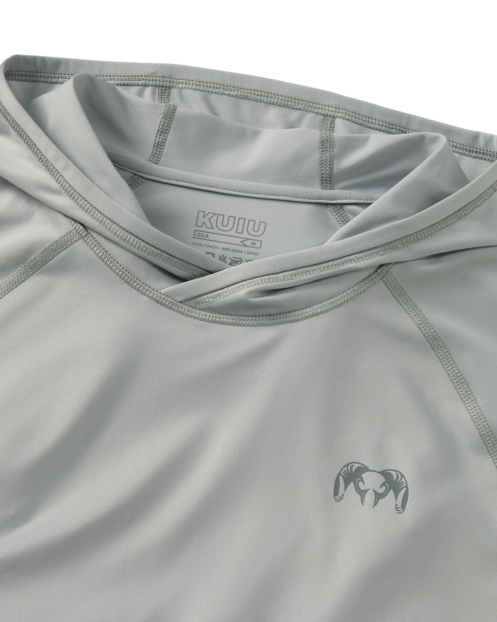 Close-up flat lay view of flatlock seams, folded hood, and KUIU Ram logo on left chest of Gila Long Sleeve Hoodie in Talus Grey