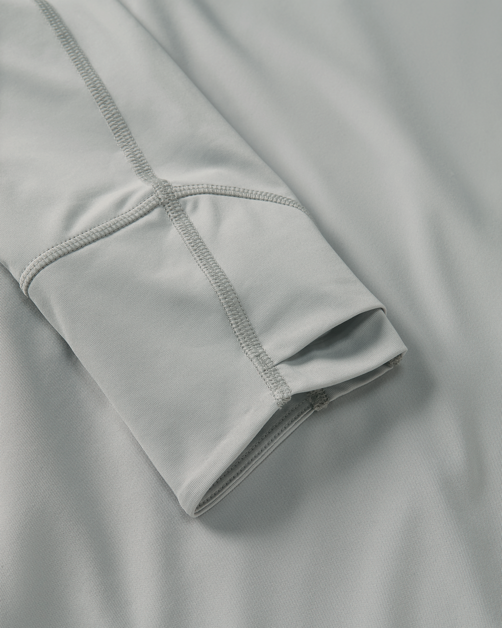 Close-up detail of layered thumbhole on Gila LS Hoodie in Talus Grey