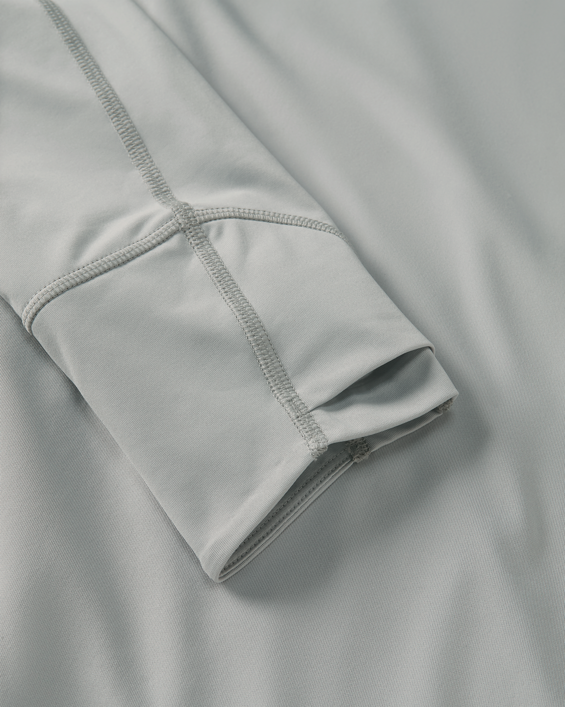 Close-up detail of layered thumbhole on Gila LS Hoodie in Talus Grey